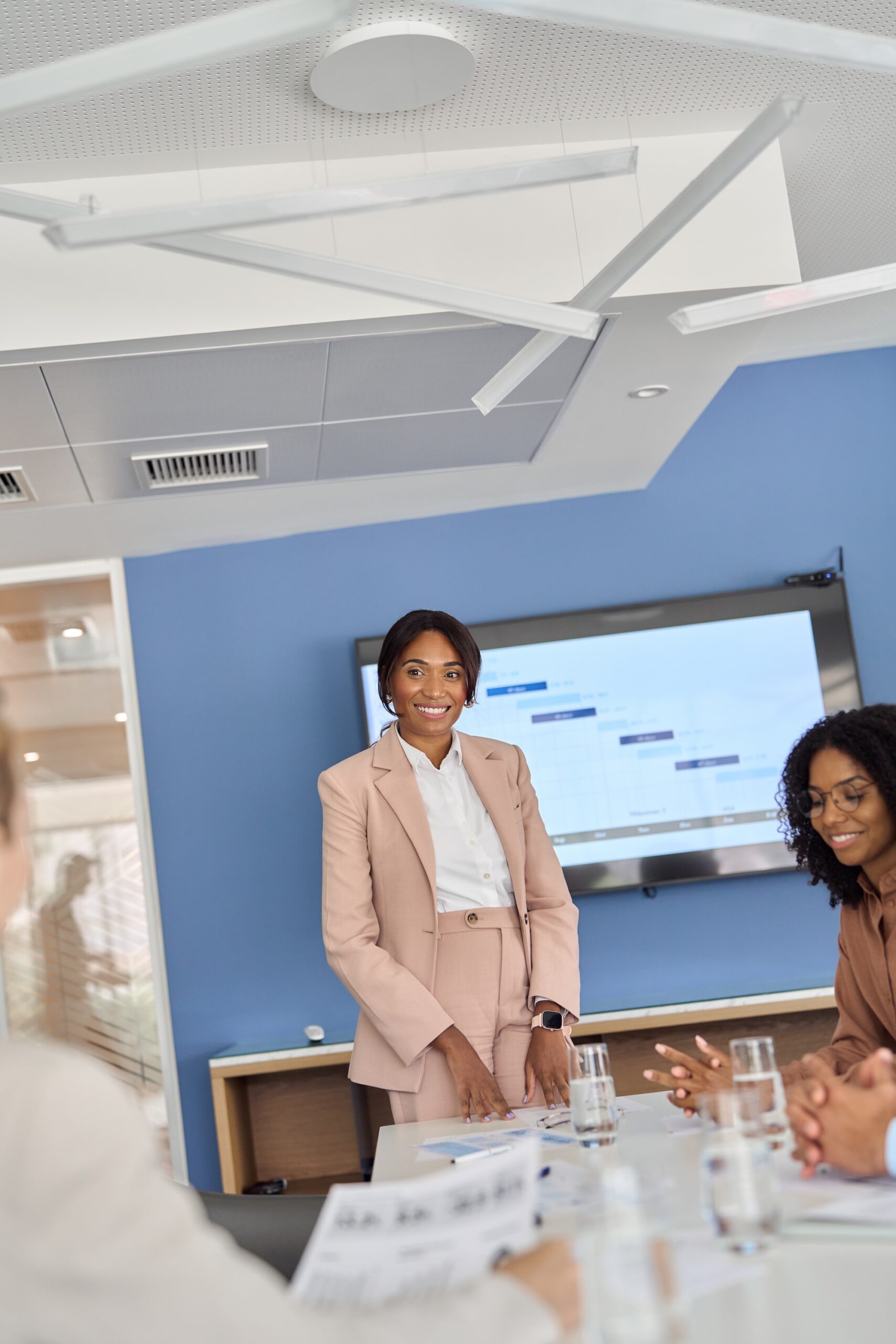 Smiling African American female executive leading business team meeting.