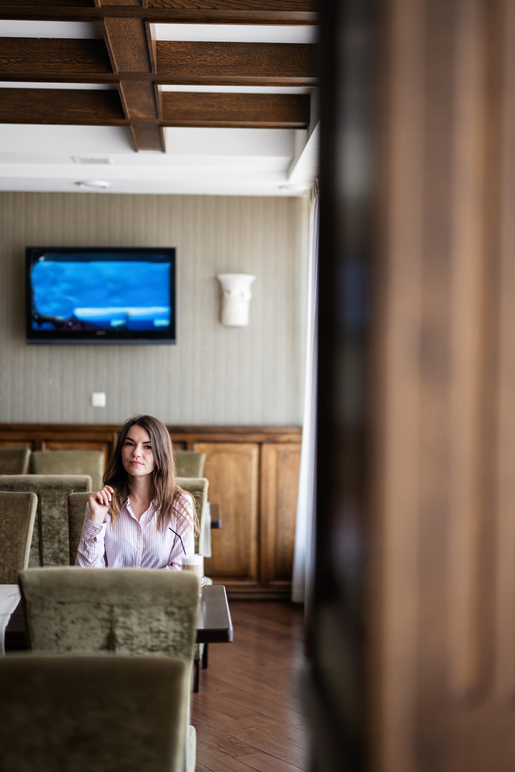 Young beautiful brunette woman sit in coffee shop cafe restaurant indoors.